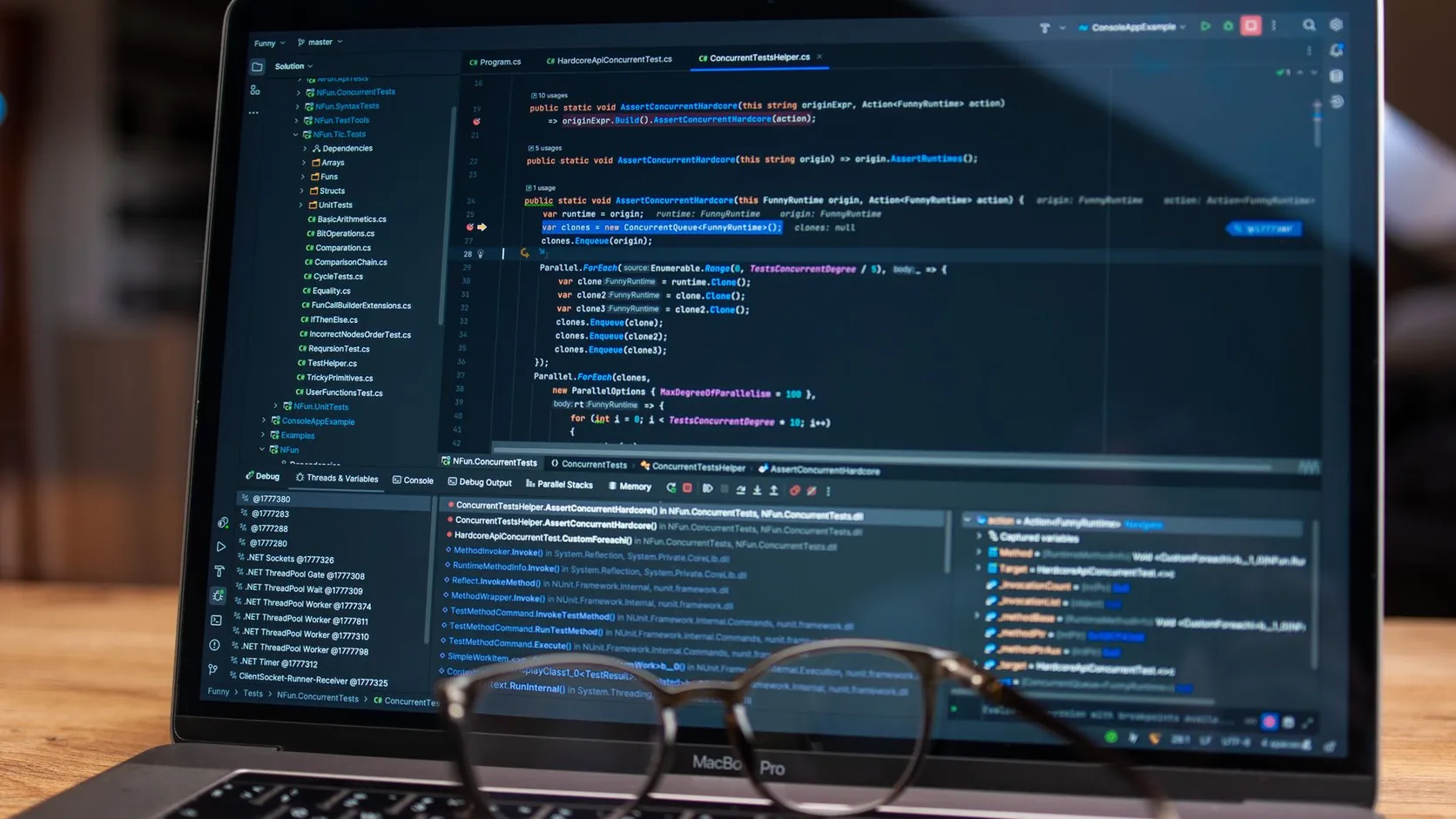 Écran d'ordinateur portable affichant un éditeur de code en mode débogage, avec une paire de lunettes posée devant